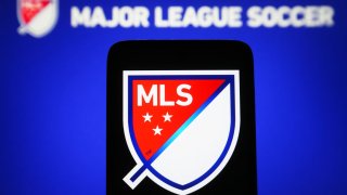 In this photo illustration, Major League Soccer (MLS) logo is seen on a smartphone and on a pc screen. (Photo Illustration by Pavlo Gonchar/SOPA Images/LightRocket via Getty Images)