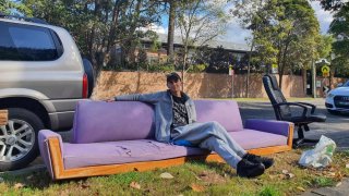 Leonardo Urbano, 30, sits on a couch that was set out for disposal in Sydney.