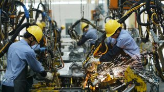 Employees on the assembly line produce cars in Mazda’s “Family” line of vehicles at China First Automobile Works (FAW) Group Haima Automobile Co., Ltd. April 6, 2005 in Haikou, Hainan Province, China.