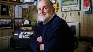 FILE – Ron Edmonds, retired senior White House photographer for the Associated Press, poses for a portrait at his home in Annandale, Va., March 16, 2013. Edmonds, who won a Pulitzer Prize for photographing the attempted assassination of President Ronald Reagan, died Friday, May 31, 2024, in Virginia at age 77.