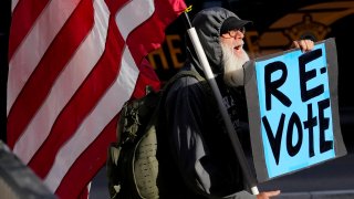 FILE - A man protests outside the Maricopa County Board of Supervisors