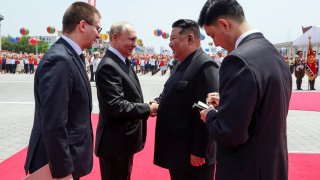 Russian President Vladimir Putin, second left, and North Korea's leader Kim Jong Un, second right, greet each other