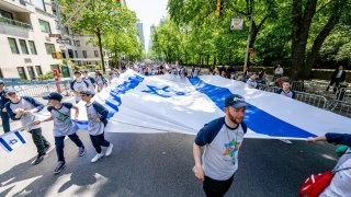 Marchers hold a giant Israeli flag during the 2022 Israel Day Parade on May 22, 2022 in New York City. (Photo by Roy Rochlin/Getty Images)