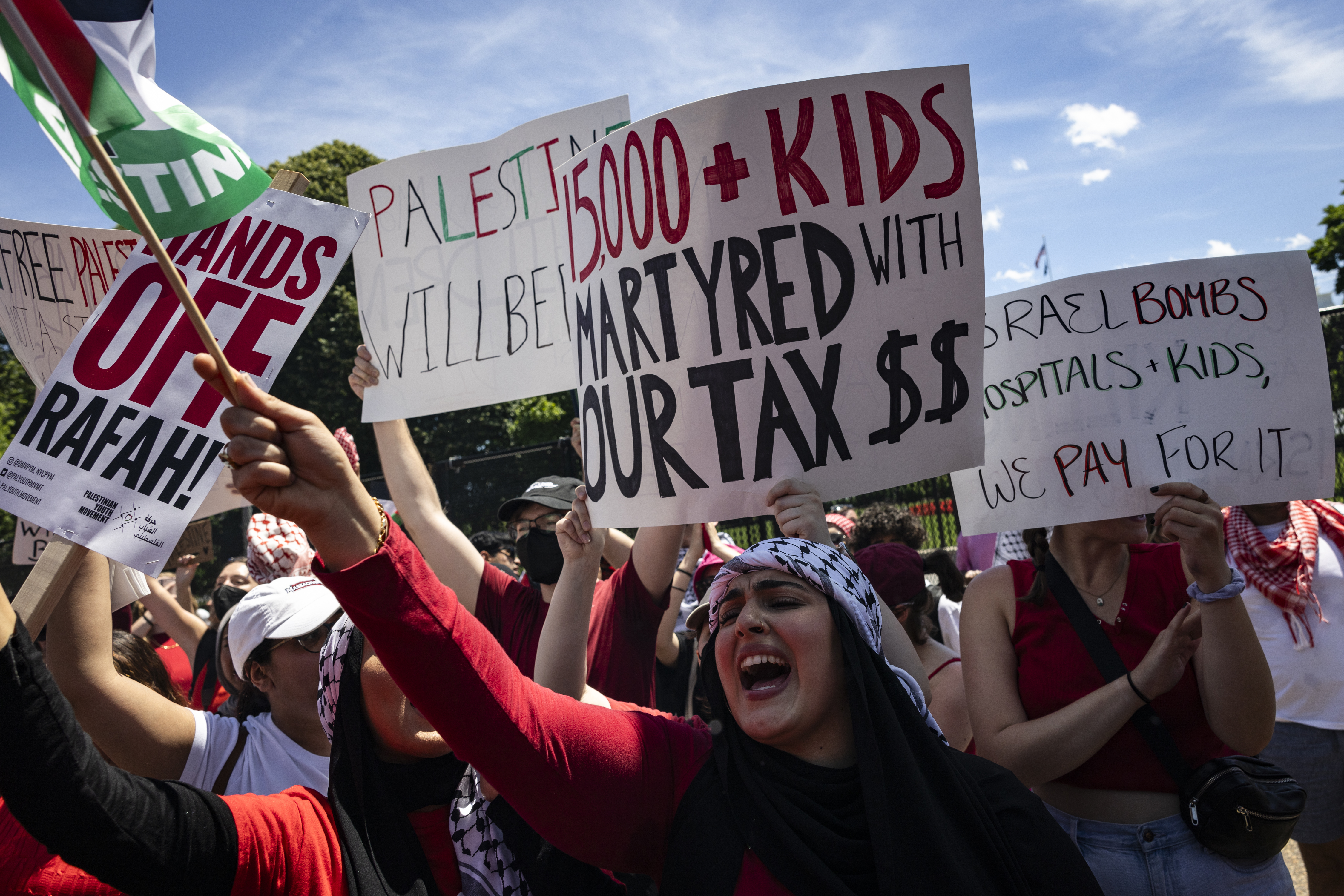 Pro-Palestinian activists hold up signs and chant on Pennsylvania Avenue 