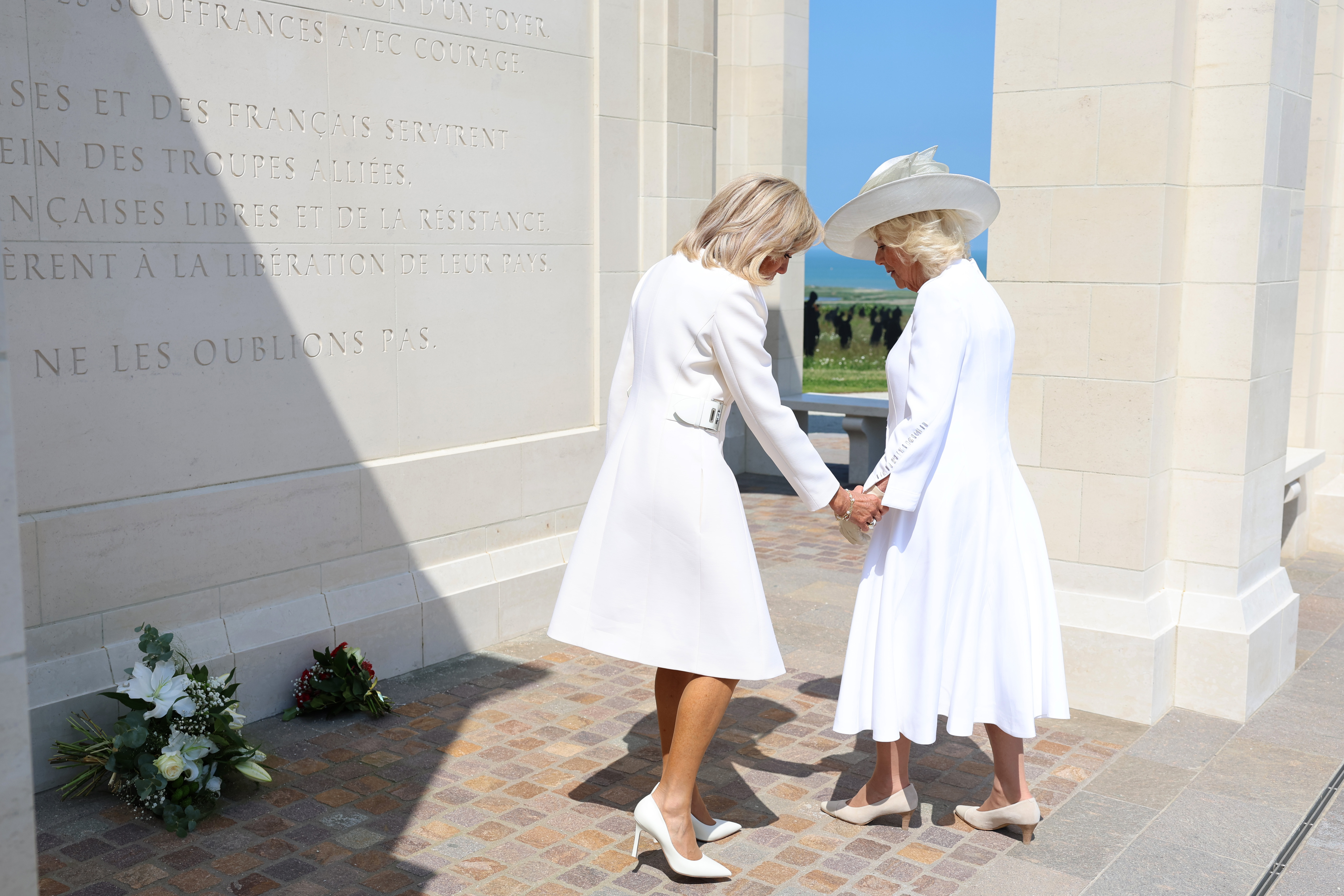 Brigitte Macron awkwardly goes to hold Queen Camilla's hand