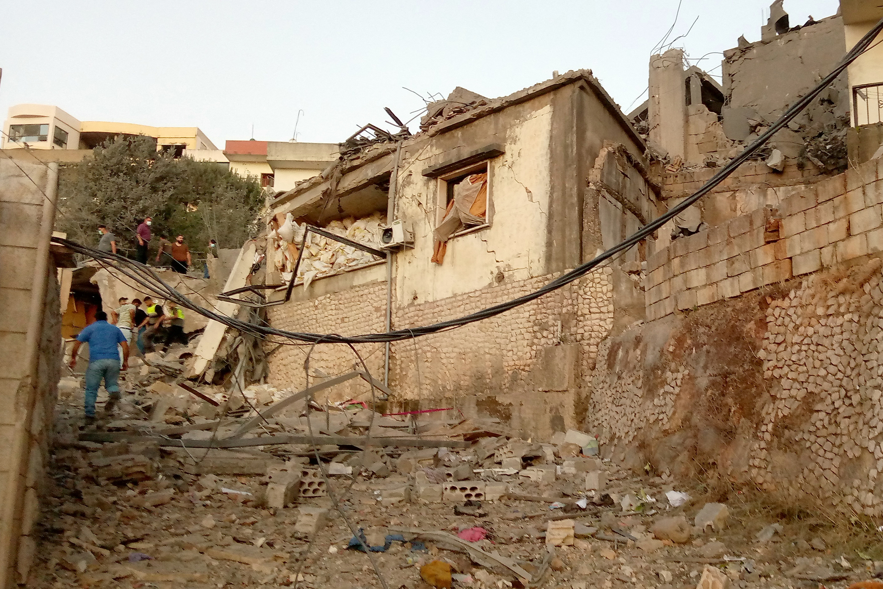 A Lebanese man walks past destroyed homes