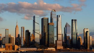 The sun sets on the skyline of midtown Manhattan, the Empire State Building and Hudson Yards in New York City on February 17, 2024.