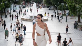 A well-dressed woman is walking at Syntagma Square in Athens, Greece, on July 3, 2024. A new measure that is passed today is concerning the right that the employer is having from now on to unilaterally impose a 6-day work week. 