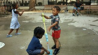 Children play in a water park on a hot day, Friday, June 21, 2024, in the Bronx Borough of New York. Tens of millions of Americans are facing major heat waves, with temperatures consistently exceeding 90 degrees (32 degrees Celsius). (AP Photo/Andres Kudacki)