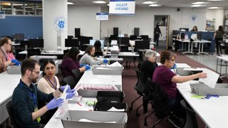 FILE – County employees open ballots in the ballot opening area of the mail ballot processing room at the Washoe County Registrar of Voters office in Reno, Nev. on Monday June 3, 2024 .Commissioners in Nevada’s second most populous county, Tuesday, July 9, 2024, refused to certify the results of two local recounts from last month’s primary, a rare move that has potential implications for the presidential race in one of the nation’s most important swing states.