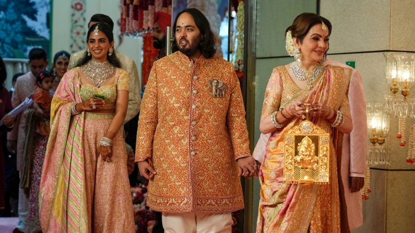 Billionaire Mukesh Ambani’s son Anant Ambani, center, stands with mother Nita Ambani, right, and sister Isha Piramal Ambani at his and Radhika Merchant’s wedding at Jio World Convention Centre in Mumbai, India, Friday, July 12, 2024.