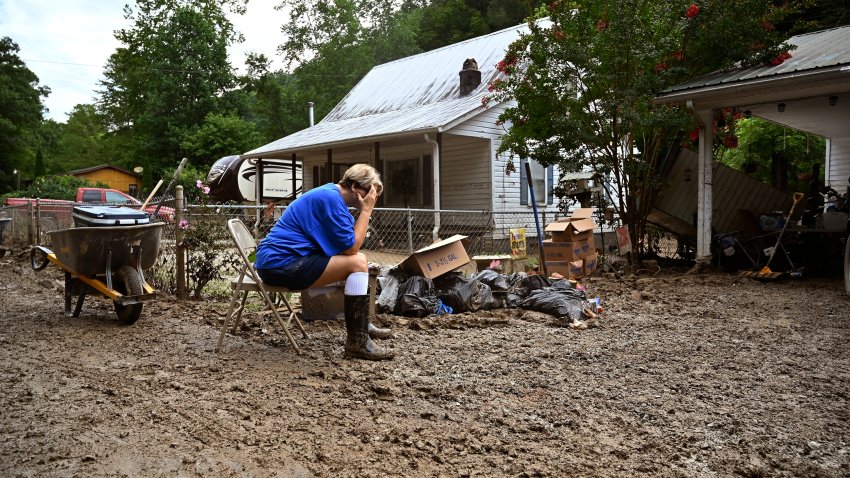 FILE - Teresa Reynolds sits as members of her community clean the debris from their flood ravaged home at Ogden Hollar in Hindman, Ky., July 30, 2022.