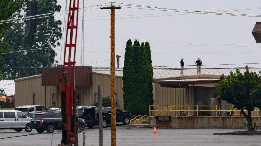 BUTLER, PENNSYLVANIA – JULY 14: Two FBI investigators scan the roof of AGR International Inc, the building adjacent to the Butler Fairgrounds, from which alleged shooter Matthew Thomas Crooks fired at former President Donald J. Trump, in the aftermath of the attempted assassination at a campaign rally on July 14, 2024 in Butler, Pennsylvania. Trump was escorted away by the Secret Service with an injury to his ear.  One attendee at the rally on July 13 was killed and two others severely injured.