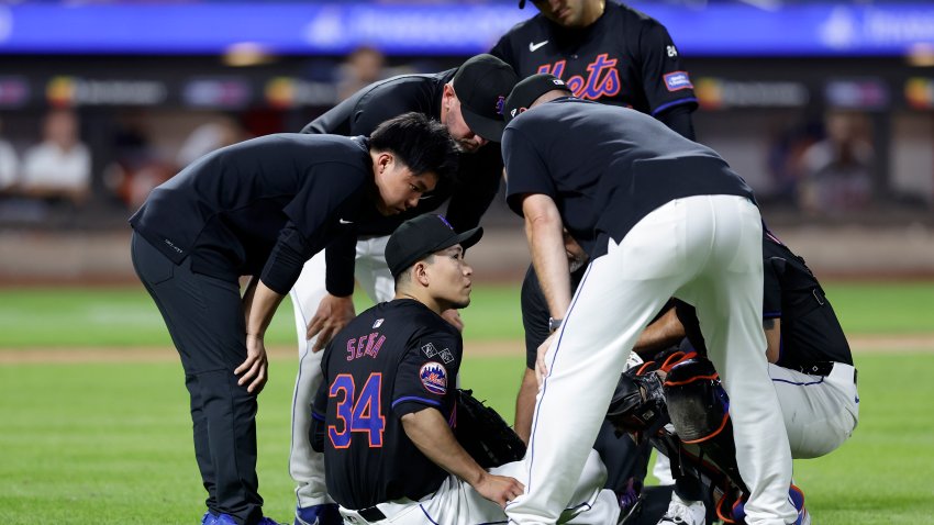 NEW YORK, NEW YORK – JULY 26:  Kodai Senga #34 of the New York Mets sits on the field and is checked out by team staff after an injury during the sixth inning against the Atlanta Braves at Citi Field on July 26, 2024 in New York City. (Photo by Jim McIsaac/Getty Images)