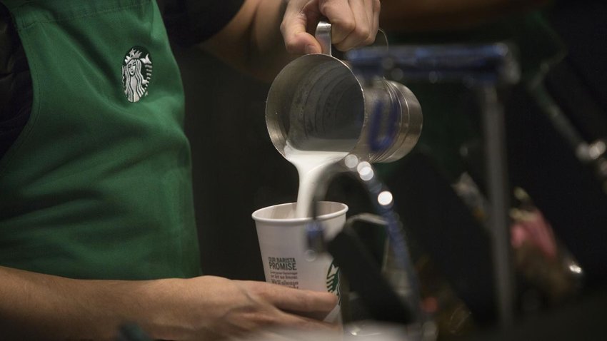 A barista pours frothed milk into a drink inside a Starbucks Corp. coffee shop in New York, Jan. 18, 2016.