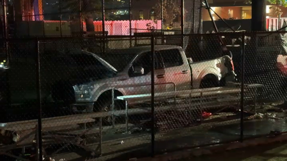 Gray truck left in park crime scene after pinning four people underneath.