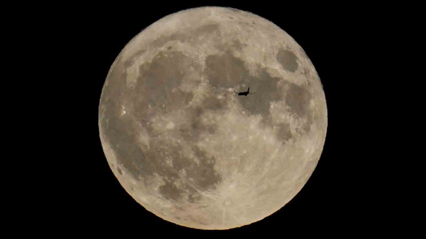 Plane passes by the moon