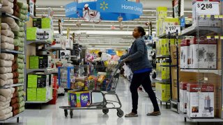 A customer pushes her shopping cart through the aisles at a Walmart store in the Porter Ranch section of Los Angeles.