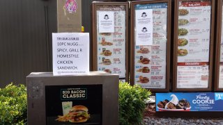 Signs reading, ‘please bear with us: we are currently experiencing interruptions in our supply chain which may affect the availability of certain products,’ is seen taped to the drive-up menu at a Wendy’s restaurant on May 06, 2020 in Miami, Florida. 