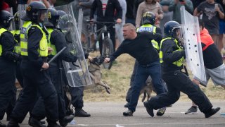 Riot police officers push back anti-migration protesters outside on Aug. 4, 2024 in Rotherham, U.K.