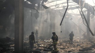 Ukrainian emergency and rescue personnel standing debris at the site of the destroyed supermarket following a Russian strike, in Kostyantynivka, eastern Donetsk region, on Aug. 9, 2024.