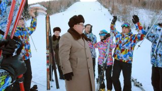 This undated picture released by North Korea’s official Korean Central News Agency (KCNA) on November 28, 2016 shows North Korean leader Kim Jong-Un (C) standing among skiers in Samjiyun. 