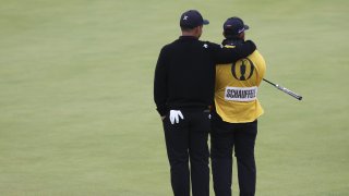 Xander Schauffele of the United States embraces his caddy Austin Kaiser on the 18th green during his final round of the British Open Golf Championships at Royal Troon golf club in Troon, Scotland, Sunday, July 21, 2024. (AP Photo/Scott Heppell)