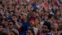 Spectators celebrate as they watch from a fan zone set up at the Club France, as Leon Marchand, of France, participates in men's 200-meter individual medley final, at the 2024 Summer Olympics, Friday, Aug. 2, 2024, in Paris, France. (AP Photo/Dar Yasin)