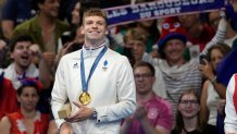 Leon Marchand of France, reacts as he stands on the podium after receiving his gold medal for the men's 200-meter individual medley final at the 2024 Summer Olympics, Friday, Aug. 2, 2024, in Nanterre, France. (AP Photo/Ashley Landis)