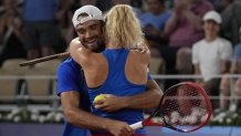 Czech Republic's Tomas Machac hugs Katerina Siniakova as they defeat China's Wang Xinyu and Zhang Zhizhen during the Mixed Doubles final tennis match at the Roland Garros stadium during the 2024 Summer Olympics, Friday, Aug. 2, 2024, in Paris, France. (AP Photo/Andy Wong)