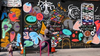 A man walks past a mural in the Harlem neighborhood of New York, Thursday, Aug. 15, 2024. (AP Photo/Pamela Smith)