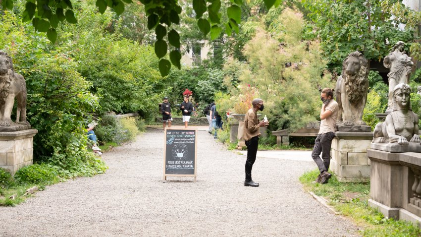 People wear protective face masks in Elizabeth Street Garden