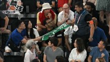 A security guard removes a banner with the name on it "Taiwan" from a fan in the audience