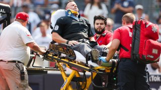 Home plate umpire Nick Marley is taken out on a stretcher during a Major League Baseball game between the Colorado Rockies and New York Yankees on August 25, 2024 at Yankee Stadium in the Bronx, New York.