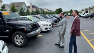 Alex Tovstanovsky, owner of used-car dealer Prestige Motor Works, checks on inventory with his general manager Ryan Caton in Naperville, Illinois, May 28, 2020.