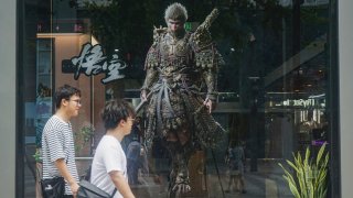 People walk past the image of the ‘Monkey King’ character, or ‘Sun Wukong’ of Chinese action role-playing game ‘Black Myth: Wukong’, developed by Chinese video game company Game Science, during its launch day in Hangzhou, in eastern China’s Zhejiang province on August 20, 2024.