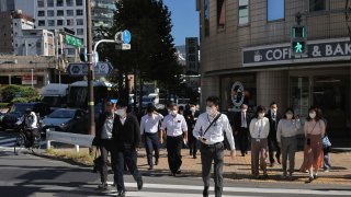  Office workers cross the street at lunch time near Tokyo Station on Oct. 20, 2022.