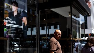 A hiring sign is displayed in the window of a Chipotle on August 22, 2024 in Alexandria, Virginia. 