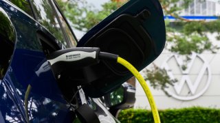 A Volkswagen ID4 electric car charges at a charging station in a parking lot at Autostadt Wolfsburg. Volkswagen AG invites its shareholders to the Annual General Meeting.