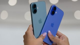 An attendee holds two iPhone 16s as Apple holds an event at the Steve Jobs Theater on its campus in Cupertino, California, on Sept. 9, 2024.