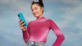 Girl using mobile phone against colored background