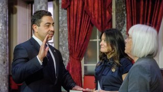 Sen. Patty Murray, D-Wash., right, administers the oath of office to Sen. George Helmy, D-N.J., left, as his wife Caroline Helmy holds the Bible during a re-enactment swearing-in.