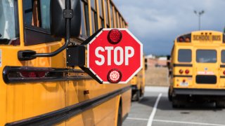 File. School bus driver checking multiple aspects of the bus before route.