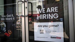 A sign for hire is posted on the door of a GameStop in New York City, April 29, 2022.