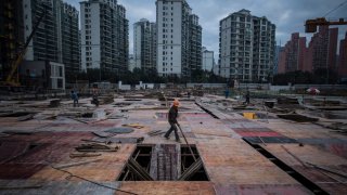 A man works at a construction site of a residential skyscraper in Shanghai on November 29, 2016. Chinese household debt has risen at an “alarming” pace as property values have soared, analysts say, raising the risk that a real estate downturn could send shockwaves through the world’s second largest economy.