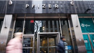 People pass by the Pfizer headquarters building in New York City, Jan. 29, 2023.