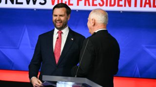 US Senator and Republican vice presidential candidate J.D. Vance (L) and Minnesota Governor and Democratic vice presidential candidate Tim Walz talk with each other at the end of the Vice Presidential debate hosted by CBS News at the CBS Broadcast Center in New York City on October 1, 2024. 