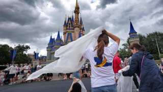 Guests at the Magic Kingdom break out ponchos at Cinderella Castle as bands of weather from Hurricane Helene move through Walt Disney World in Bay Lake, Florida, on Sept. 26, 2024. 