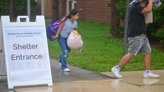 People arrive to shelter at Buffalo Creek Middle School ahead of Hurricane Milton expected landfall in Bradenton, Florida on October 9, 2024.