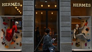 A woman walks past a Hermes boutique in Via Monte Napoleone, a famous upscale shopping street in Milan.